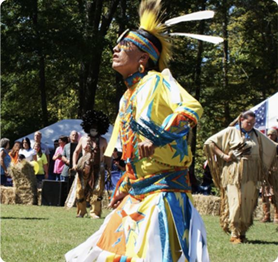 Native American dressed in cerimonial gear chanting